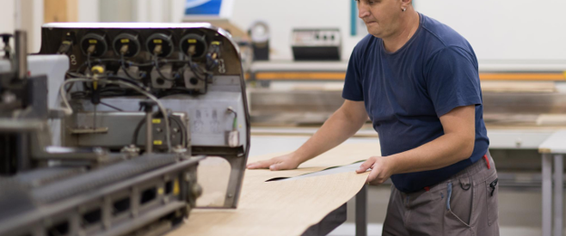 Technician operating a vinyl cutting machine to produce custom signage materials in Melbourne