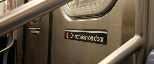 Aluminium composite directional signage installed on a public transport door in Melbourne
